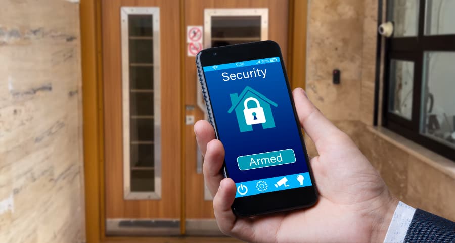 Individual using cell phone to arm a security system